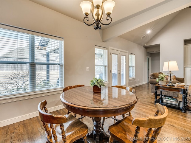 dining space with light wood-type flooring, plenty of natural light, and vaulted ceiling