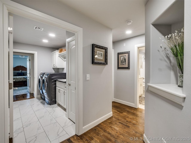 laundry room featuring visible vents, washer and dryer, baseboards, marble finish floor, and cabinet space