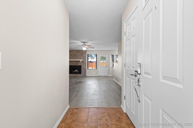 hallway with tile patterned floors and a textured ceiling