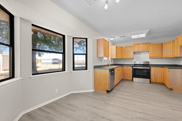 kitchen featuring sink, light hardwood / wood-style flooring, stainless steel appliances, a textured ceiling, and light brown cabinetry