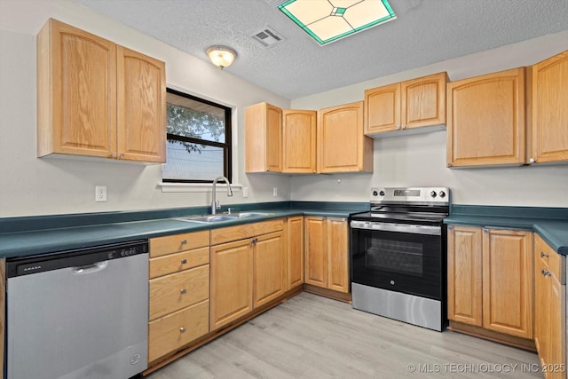 kitchen featuring sink, a textured ceiling, light brown cabinets, appliances with stainless steel finishes, and light hardwood / wood-style floors