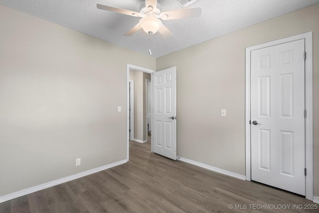 unfurnished bedroom with hardwood / wood-style flooring, ceiling fan, and a textured ceiling