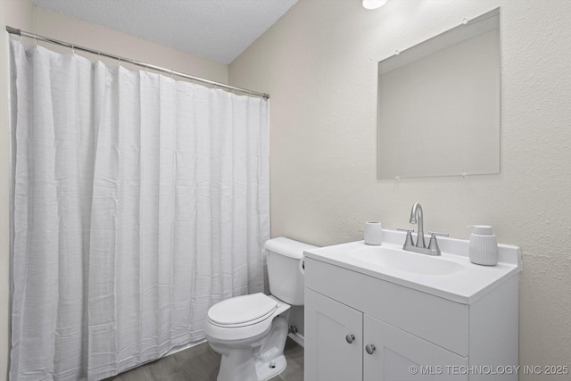 bathroom with vanity, toilet, hardwood / wood-style floors, and a textured ceiling