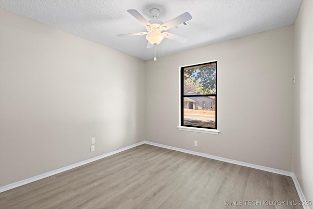 spare room with a textured ceiling, light hardwood / wood-style flooring, and ceiling fan