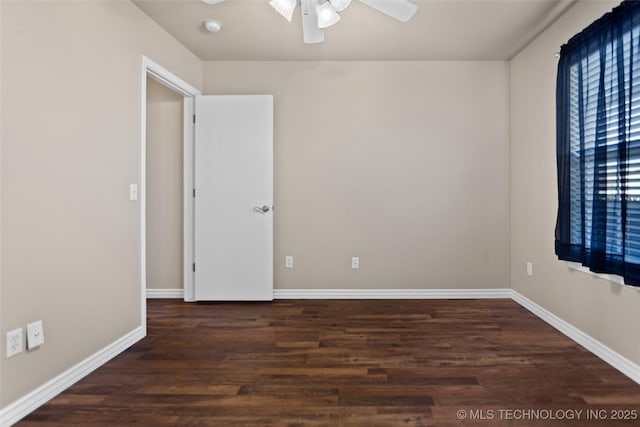 spare room with dark wood-type flooring and ceiling fan