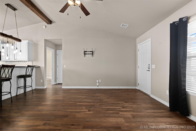 interior space with dark hardwood / wood-style flooring, vaulted ceiling with beams, and ceiling fan