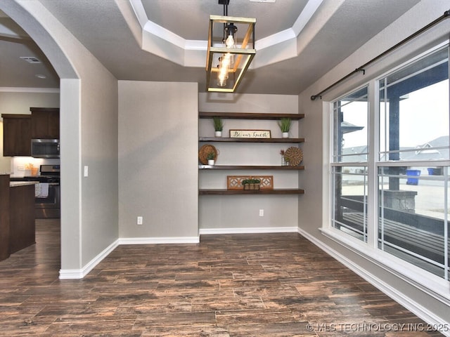 spare room featuring crown molding, a tray ceiling, and dark hardwood / wood-style flooring