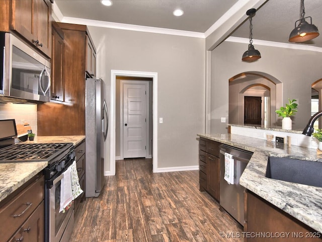 kitchen featuring pendant lighting, sink, appliances with stainless steel finishes, backsplash, and light stone countertops