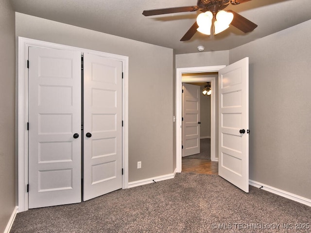 unfurnished bedroom featuring ceiling fan, a closet, and dark colored carpet