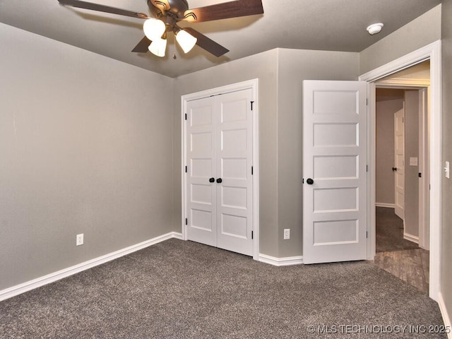 unfurnished bedroom featuring ceiling fan, dark carpet, and a closet