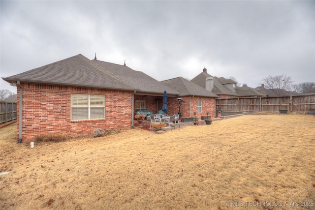 back of house featuring a patio area and a lawn