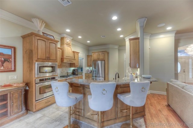 kitchen featuring appliances with stainless steel finishes, backsplash, a kitchen breakfast bar, custom exhaust hood, and kitchen peninsula