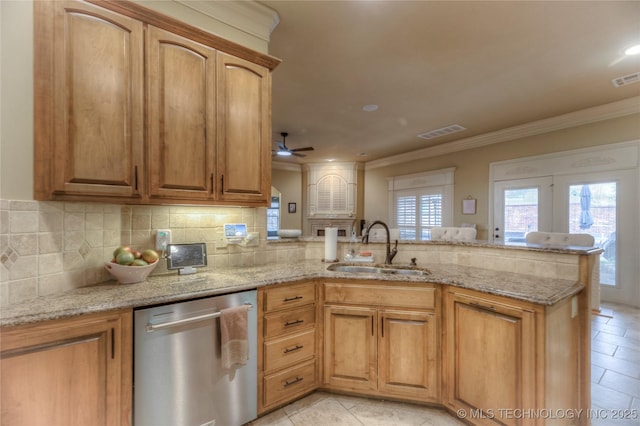 kitchen featuring dishwasher, sink, light stone counters, and kitchen peninsula