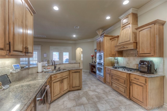 kitchen featuring sink, custom exhaust hood, tasteful backsplash, ornamental molding, and appliances with stainless steel finishes