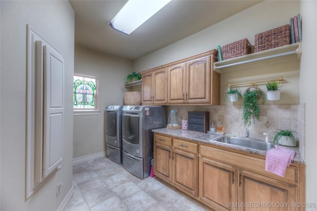 clothes washing area with cabinets, sink, and independent washer and dryer