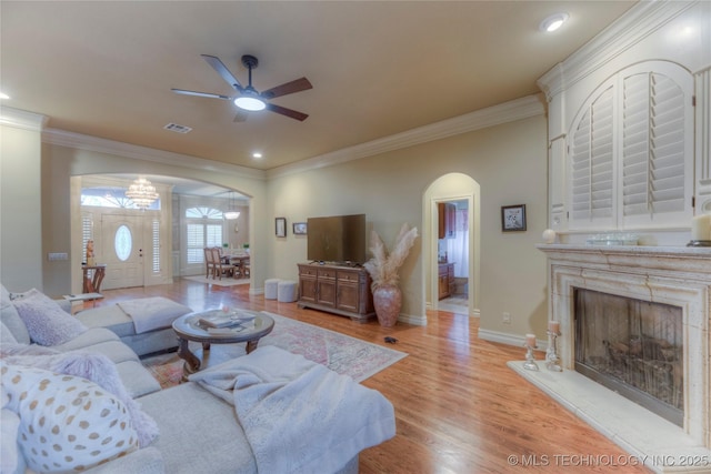 living room with ornamental molding, ceiling fan, and light hardwood / wood-style floors