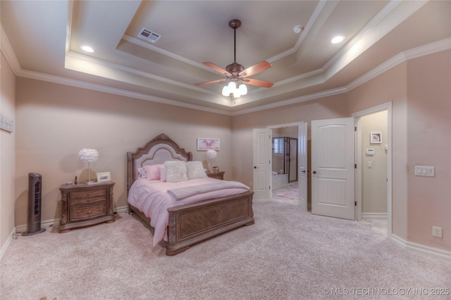 carpeted bedroom with ornamental molding and a tray ceiling