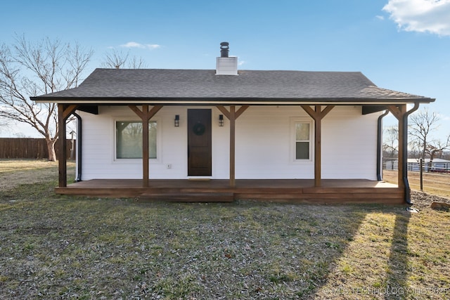 rear view of house with a porch and a yard