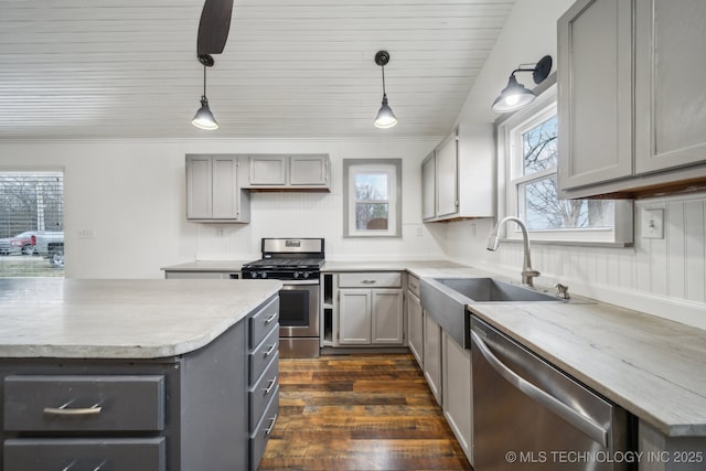 kitchen featuring appliances with stainless steel finishes, sink, hanging light fixtures, and gray cabinetry