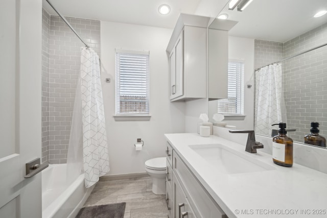 full bathroom with vanity, shower / bath combo, and toilet