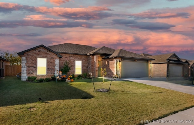 prairie-style home featuring a garage and a lawn