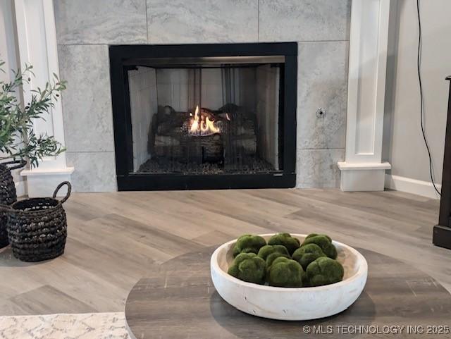 interior details featuring hardwood / wood-style floors and a tile fireplace