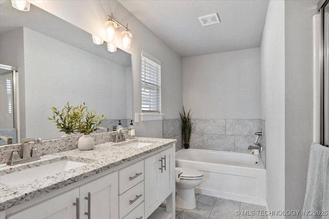 bathroom featuring a tub to relax in, toilet, and vanity