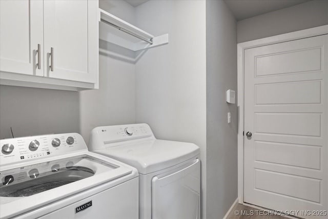 washroom with cabinets and washing machine and clothes dryer