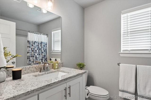 bathroom featuring vanity, a shower with curtain, and toilet