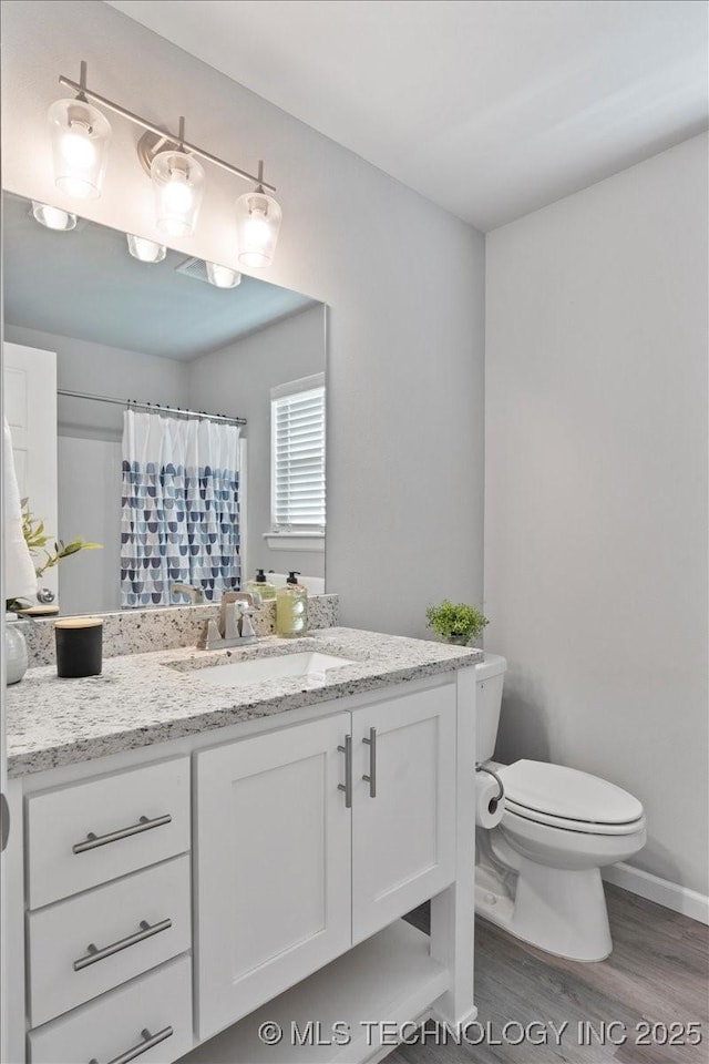 bathroom featuring vanity, toilet, curtained shower, and hardwood / wood-style floors