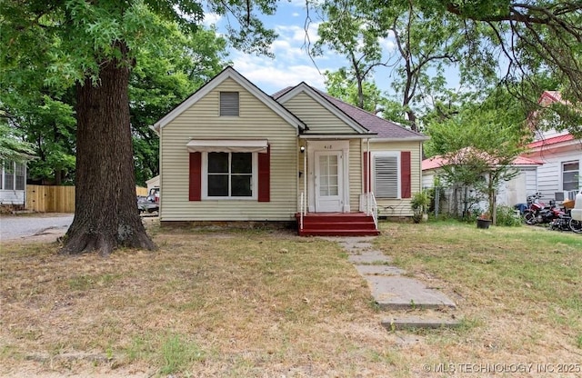 bungalow-style home with a front yard