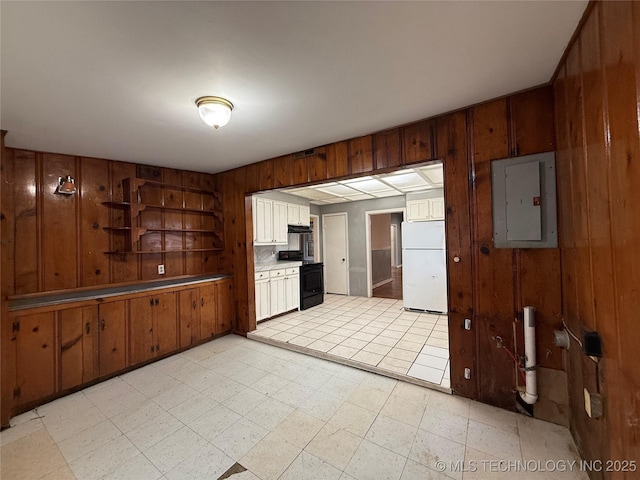 kitchen featuring white refrigerator, range with electric stovetop, electric panel, and wooden walls