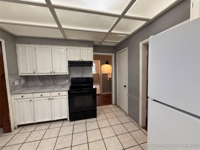 kitchen featuring light tile patterned flooring, white cabinetry, white fridge, coffered ceiling, and black range with electric stovetop