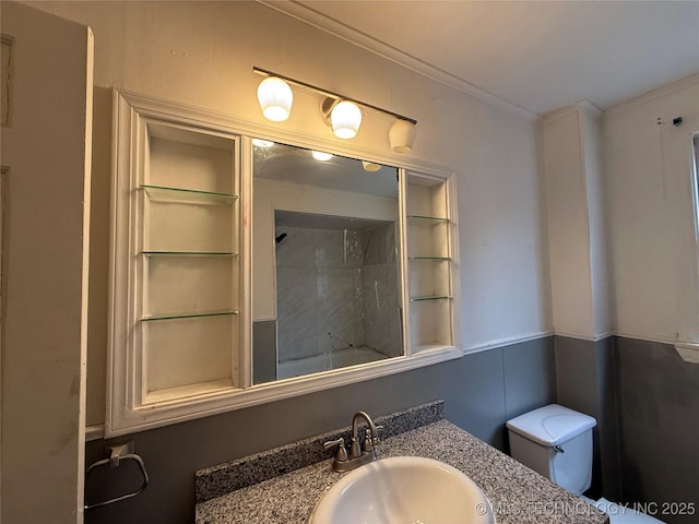 bathroom with ornamental molding, vanity, and toilet