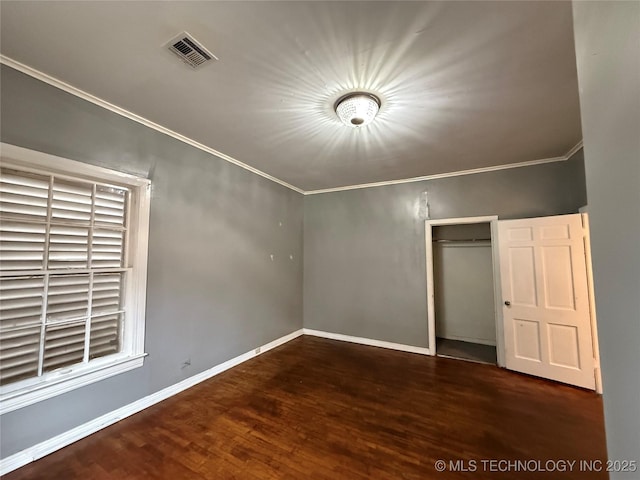 unfurnished bedroom featuring ornamental molding, dark hardwood / wood-style floors, and a closet