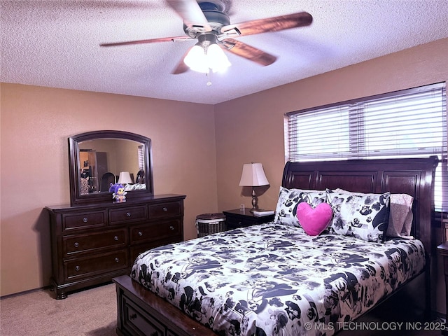 bedroom featuring ceiling fan, light colored carpet, and a textured ceiling