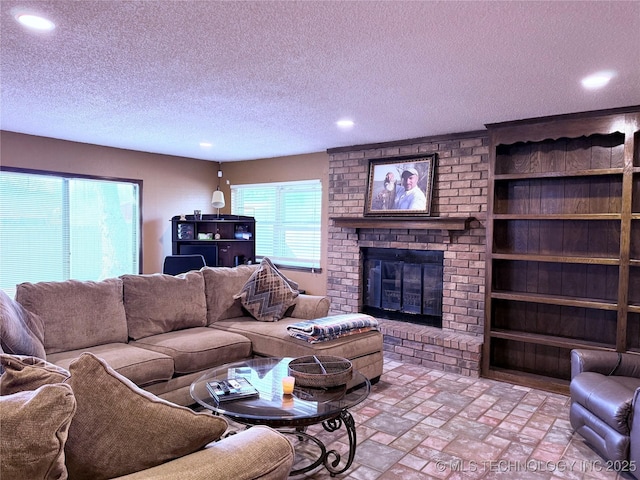 living room featuring a brick fireplace and a textured ceiling