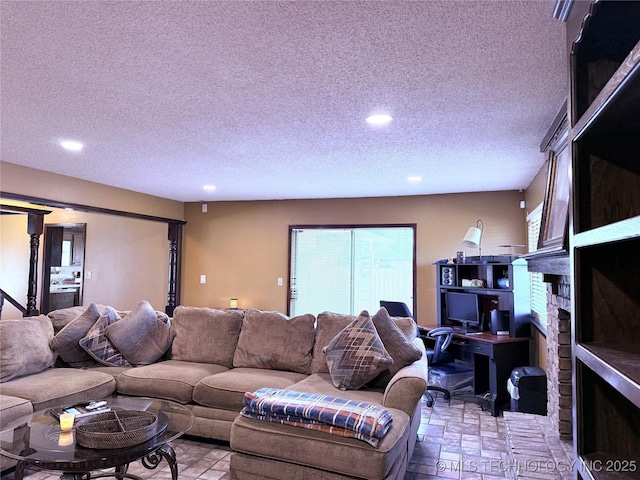 living room with a fireplace and a textured ceiling