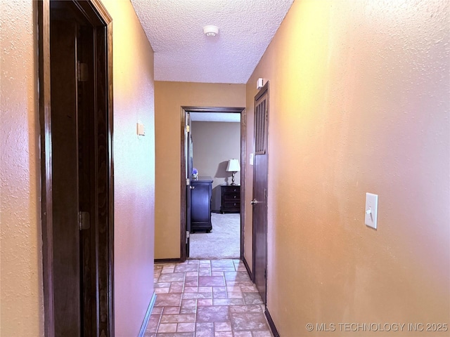 hall with a textured ceiling