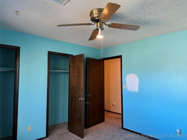 unfurnished bedroom with ceiling fan, a textured ceiling, and carpet flooring