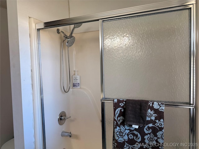 bathroom featuring bath / shower combo with glass door