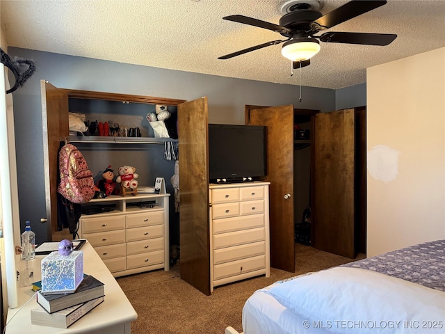 carpeted bedroom with ceiling fan, a textured ceiling, and a closet