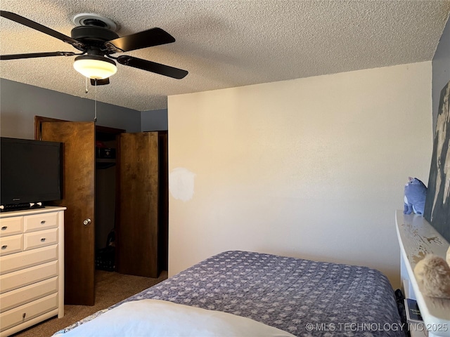 bedroom featuring ceiling fan, dark carpet, and a textured ceiling