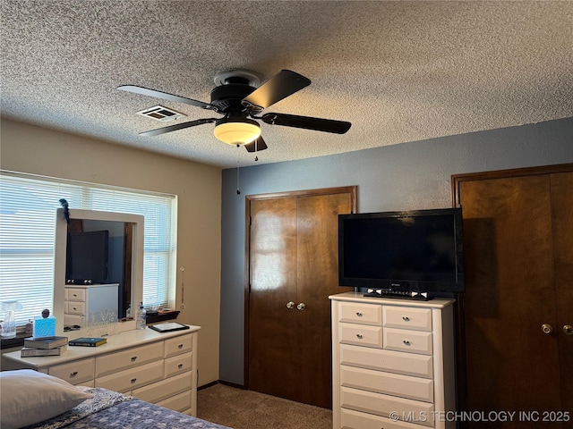 carpeted bedroom with ceiling fan and a textured ceiling