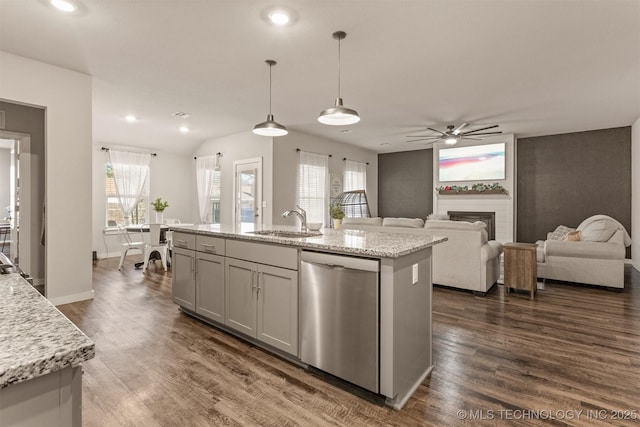 kitchen with dark wood-type flooring, sink, decorative light fixtures, stainless steel dishwasher, and an island with sink