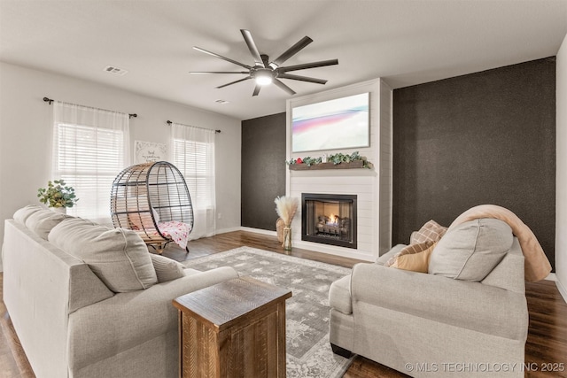 living room featuring hardwood / wood-style flooring, a fireplace, and ceiling fan