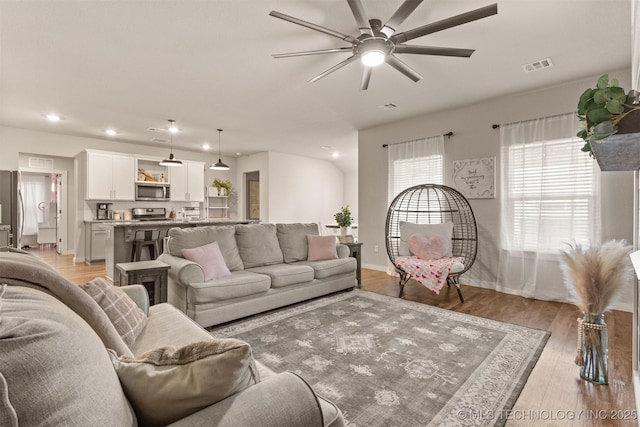 living room featuring ceiling fan and light wood-type flooring