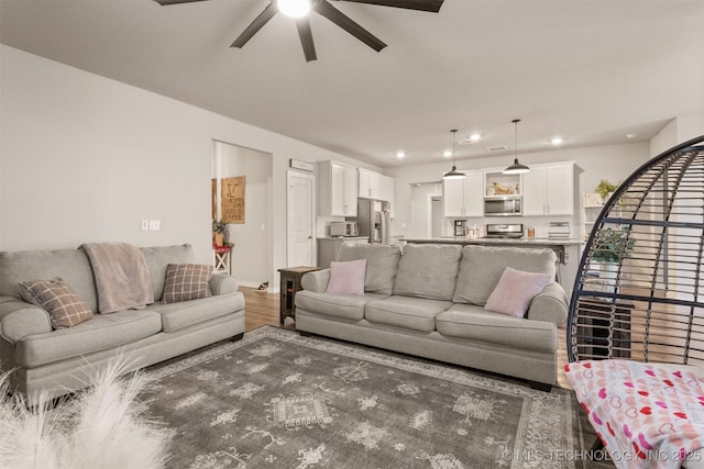 living room with ceiling fan and dark hardwood / wood-style flooring