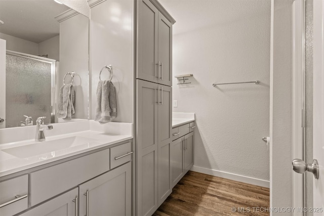 bathroom featuring vanity, an enclosed shower, and hardwood / wood-style floors