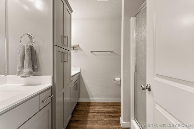 bathroom with hardwood / wood-style flooring, vanity, and an enclosed shower